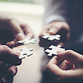 © Johnstocker | stock.adobe.com | (Hand holding jigsaw puzzles, Business partnership concept)